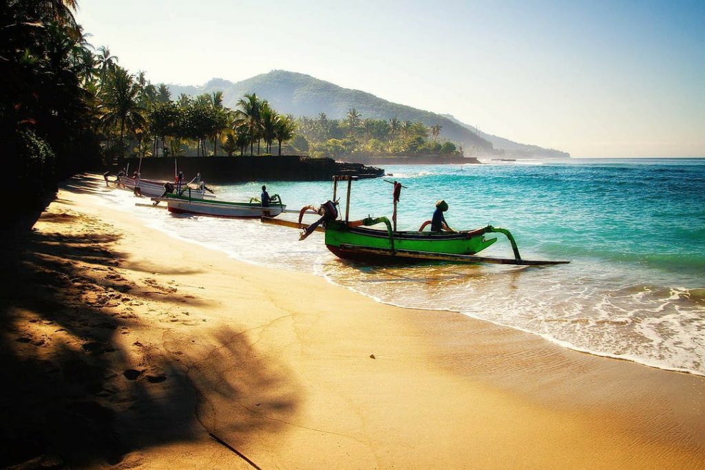 Golden sands, aqua seas and local boats on a beach in Bali