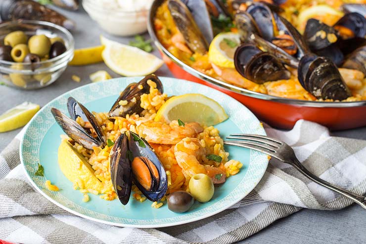 This Spanish Seafood Paella features a crusty saffron and veggie infused layer of rice topped with squid, mussels, and shrimp. The best seafood dish ever! 