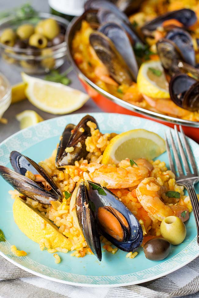 This Spanish Seafood Paella features a crusty saffron and veggie infused layer of rice topped with squid, mussels, and shrimp. The best seafood dish ever! 